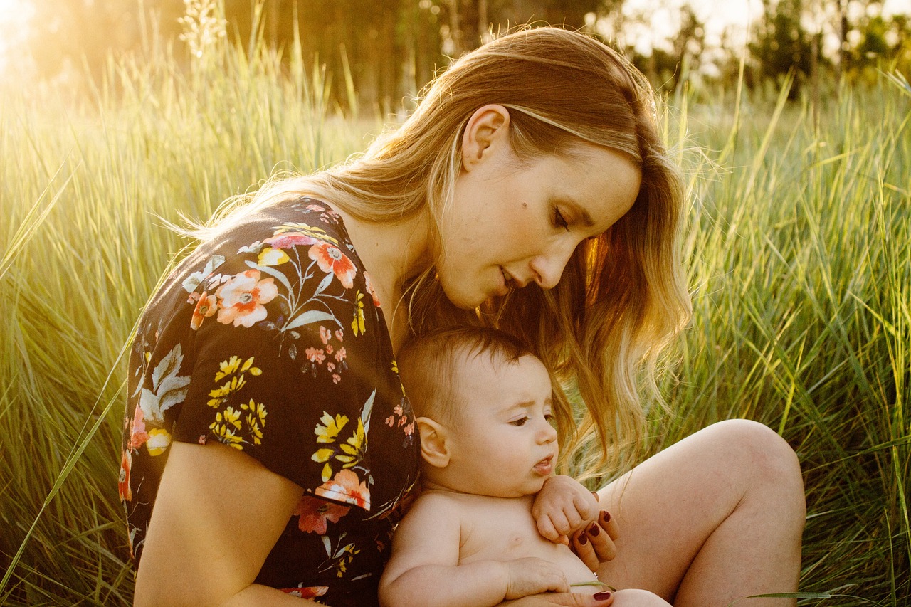 Mother breastfeeding while sitting with baby